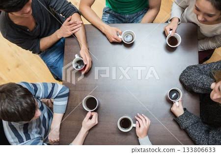 People sitting around table drinking coffee People sitting around table drinking coffee 133806633
