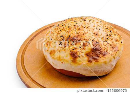 Freshly baked bread on wooden board with golden crust and seeds 133806973