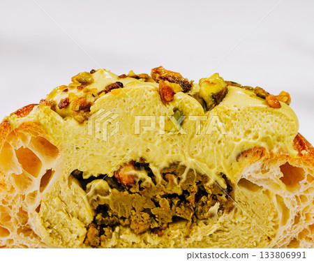 Delightful dessert featuring creamy filling and crunchy topping with pistachios 133806991