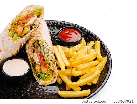 Delicious chicken wrap served with crispy fries and dipping sauces for lunch Delicious chicken wrap served with crispy fries and dipping sauces for lunch 133807021