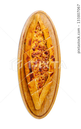 Savory Turkish pide served on a wooden platter in a restaurant setting Savory Turkish pide served on a wooden platter in a restaurant setting 133807067
