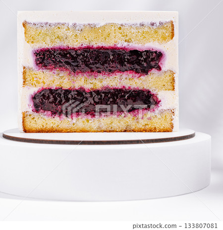 Delicious layered cake with berry filling on a white pedestal Delicious layered cake with berry filling on a white pedestal 133807081