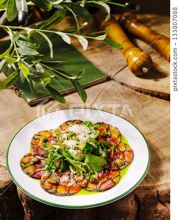 Colorful vegetable dish garnished with herbs served on rustic wooden table Colorful vegetable dish garnished with herbs served on rustic wooden table 133807088
