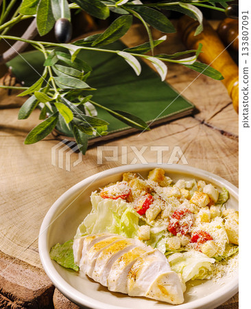Delicious salad with grilled chicken and fresh ingredients on a wooden table 133807091