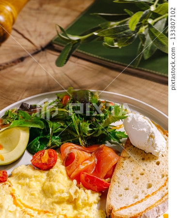 Delicious breakfast plate with scrambled eggs, smoked salmon, and fresh greens Delicious breakfast plate with scrambled eggs, smoked salmon, and fresh greens 133807102