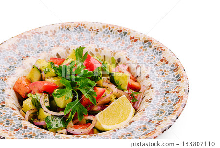 Fresh and colorful salad with cucumber, tomato, and lime in decorative bowl Fresh and colorful salad with cucumber, tomato, and lime in decorative bowl 133807110