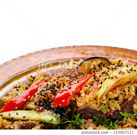 Delicious rice dish with vegetables and meat served on a traditional plate Delicious rice dish with vegetables and meat served on a traditional plate 133807111