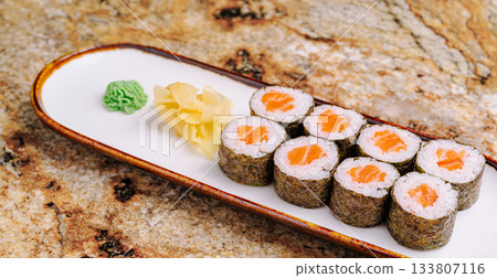 Sushi rolls with ginger and wasabi served on a plate 133807116