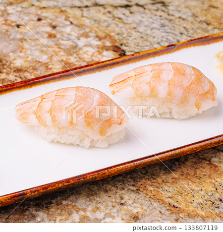 Delicate shrimp sushi served on a white plate at a sushi restaurant 133807119