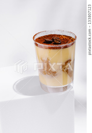 Coffee dessert in clear cup with cocoa and coffee beans on white background Coffee dessert in clear cup with cocoa and coffee beans on white background 133807123