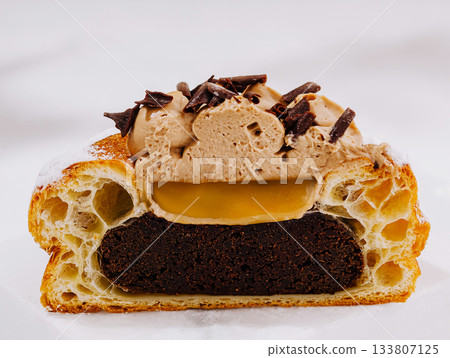 Delicious layered dessert featuring chocolate, cream, and filling 133807125