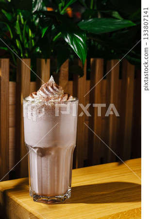 Delicious chocolate shake served in a tall glass at a cozy cafe Delicious chocolate shake served in a tall glass at a cozy cafe 133807141