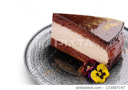 Delicate chocolate cake with creamy filling and floral decoration on plate Delicate chocolate cake with creamy filling and floral decoration on plate 133807147
