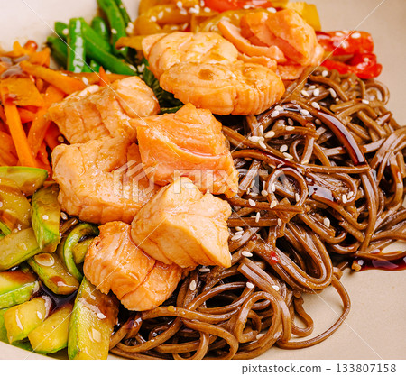 Fresh salmon and vegetable soba noodle bowl served in a stylish dish 133807158