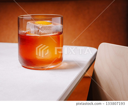 Refreshing cocktail served on a classy table with warm tones 133807193