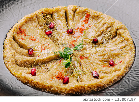 Delightful traditional dish with pomegranate garnishes served on a plate Delightful traditional dish with pomegranate garnishes served on a plate 133807197