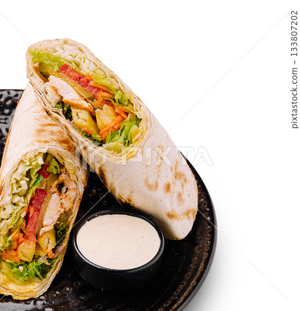 Cooking healthy wrap with grilled chicken and fresh vegetables served on a plate Cooking healthy wrap with grilled chicken and fresh vegetables served on a plate 133807202