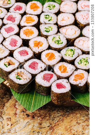 Colorful sushi rolls arranged neatly on a bamboo mat with vibrant ingredients Colorful sushi rolls arranged neatly on a bamboo mat with vibrant ingredients 133807208