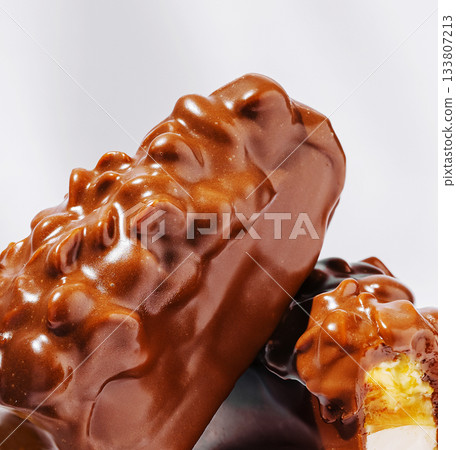 Chocolate-covered treats with a creamy filling displayed on a plain surface 133807213