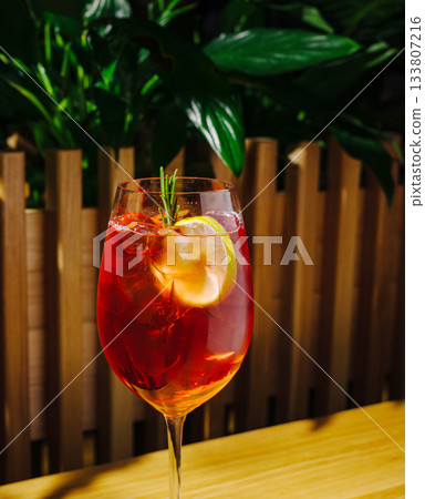 Refreshing cocktail served in a clear glass with lemon and rosemary garnish Refreshing cocktail served in a clear glass with lemon and rosemary garnish 133807216