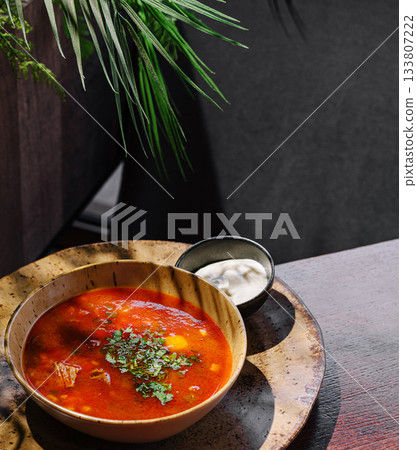 Delicious soup served in a rustic bowl at a cozy cafe during lunch time Delicious soup served in a rustic bowl at a cozy cafe during lunch time 133807222
