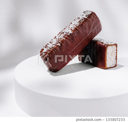 Delicious chocolate coconut bars displayed on a round pedestal Delicious chocolate coconut bars displayed on a round pedestal 133807233