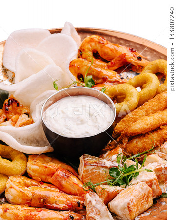 Seafood platter with shrimp, fish and dips served on a wooden tray Seafood platter with shrimp, fish and dips served on a wooden tray 133807240