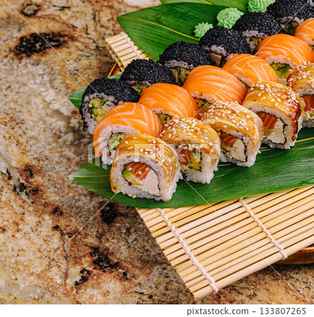 Colorful sushi platter featuring various rolls on a bamboo mat Colorful sushi platter featuring various rolls on a bamboo mat 133807265