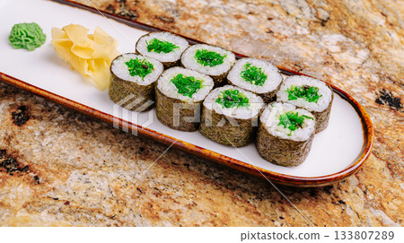 Delicious sushi rolls displayed on a plate with green wasabi and ginger Delicious sushi rolls displayed on a plate with green wasabi and ginger 133807289