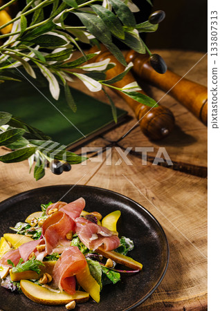 Fresh salad with prosciutto, apples, and nuts served on rustic table Fresh salad with prosciutto, apples, and nuts served on rustic table 133807313