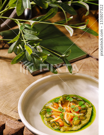 Creative dish served on rustic wooden table with green garnish Creative dish served on rustic wooden table with green garnish 133807322