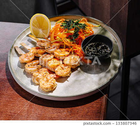Shrimp and salad served on a silver plate with fresh lemon slice Shrimp and salad served on a silver plate with fresh lemon slice 133807346