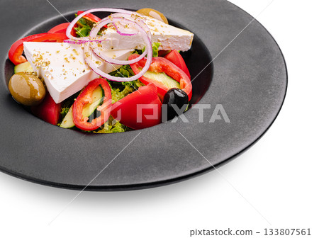 Fresh vegetable salad with cheese and olives served on a black plate Fresh vegetable salad with cheese and olives served on a black plate 133807561