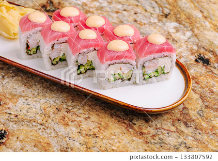 Sushi platter with fresh rolls and wasabi on a marbled surface 133807592