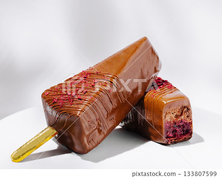Delicious chocolate popsicles with berry filling on a clean table 133807599
