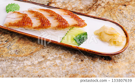 Delicious grilled fish sushi with cucumber and ginger on a plate Delicious grilled fish sushi with cucumber and ginger on a plate 133807639