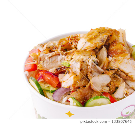Delicious bowl of grilled chicken with fresh vegetables served in a restaurant 133807645