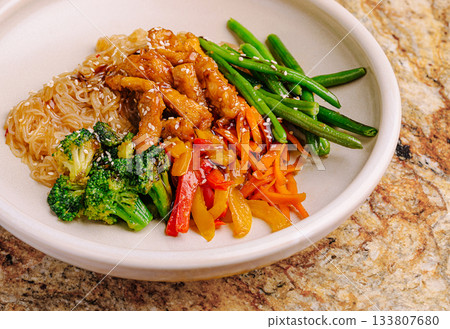 Healthy stir-fry meal with chicken, noodles, and colorful vegetables Healthy stir-fry meal with chicken, noodles, and colorful vegetables 133807680