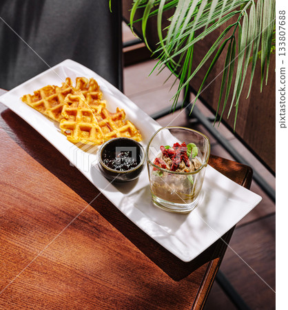 Delicious waffles served with sweet toppings at a cozy cafe in afternoon light 133807688