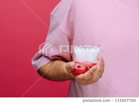 Colorful dessert in a glass held by a person with a pink shirt Colorful dessert in a glass held by a person with a pink shirt 133807700