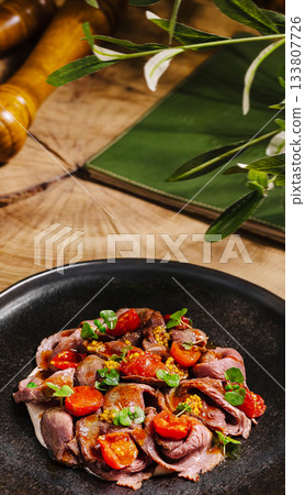 Delicious roast beef with cherry tomatoes served on a rustic table 133807726