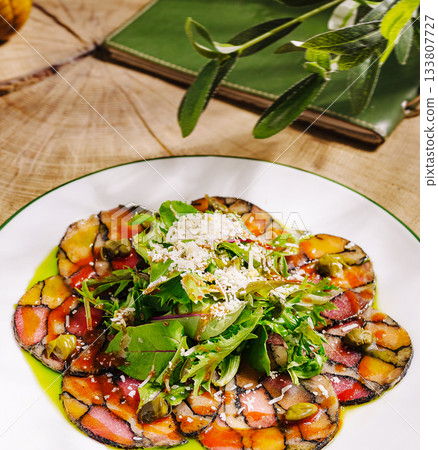 Colorful vegetable carpaccio served on a rustic wooden table with greens 133807727