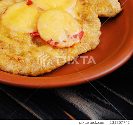 Delicious fried plantains topped with melted cheese and sliced peppers 133807742