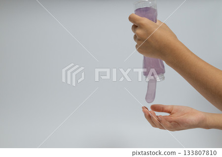 黏液從玻璃杯和一隻手流出 黏液從玻璃杯和一隻手流出 133807810