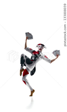 Joker jumping with oversized playing cards in energetic pose 133808039