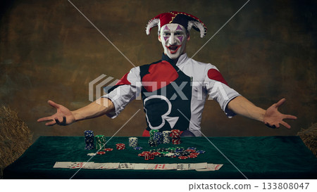 Joker character presenting casino chips and playing cards at gaming table Joker character presenting casino chips and playing cards at gaming table 133808047