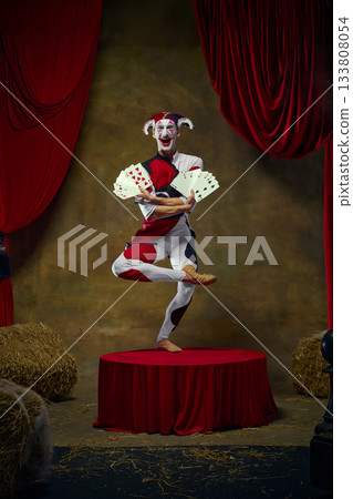 Jester balancing multiple retro card fans in dynamic stage pose Jester balancing multiple retro card fans in dynamic stage pose 133808054