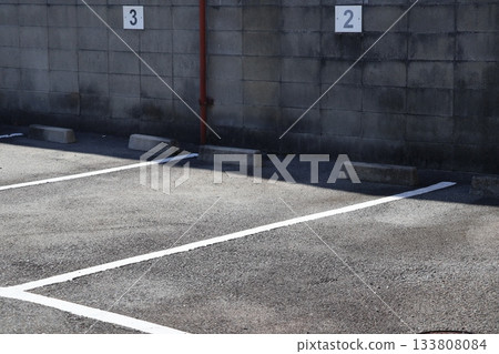 A parking lot with a white line and numbers written on a brick wall A parking lot with a white line and numbers written on a brick wall 133808084