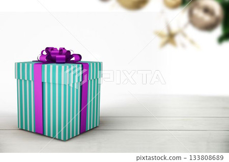flat design striped gift box is resting on pale wood surface, blurred ornaments hanging behind flat design striped gift box is resting on pale wood surface, blurred ornaments hanging behind 133808689