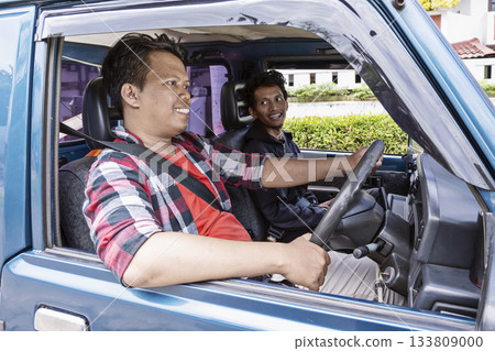 Two Indonesian southeast asian men are taking a drive and going on a trip in a car 133809000